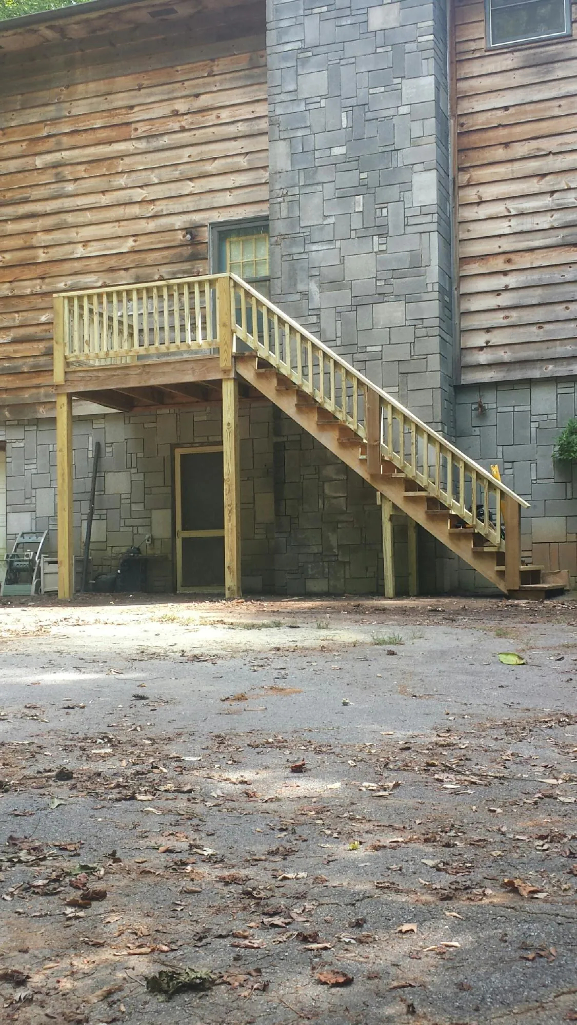 New pressure treated deck and stair landing on a log home in New Castle